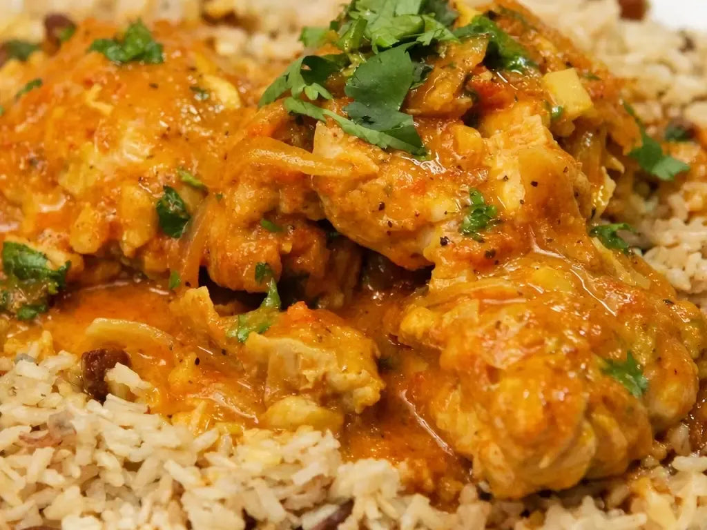Poulet au curry servi sur riz parfumé aux herbes