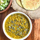a bowl of soup sitting on top of a wooden table 
