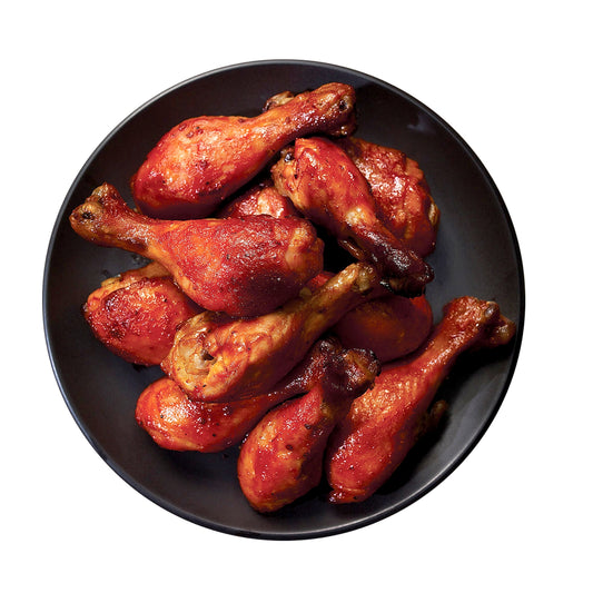 a close up of a plate of roasted drumsticks on a table